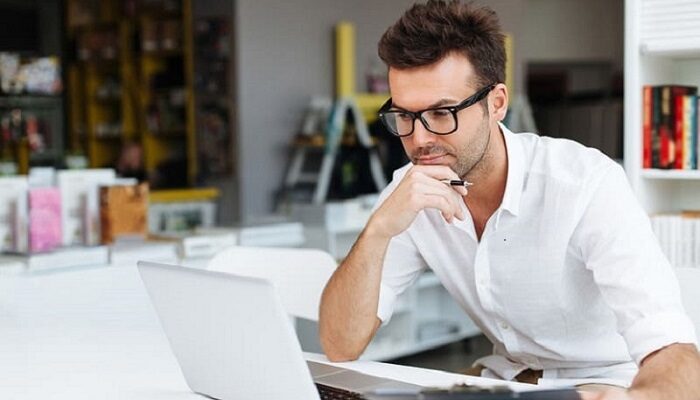 Фото мужчина в очках на рабочем места за ноутбуком